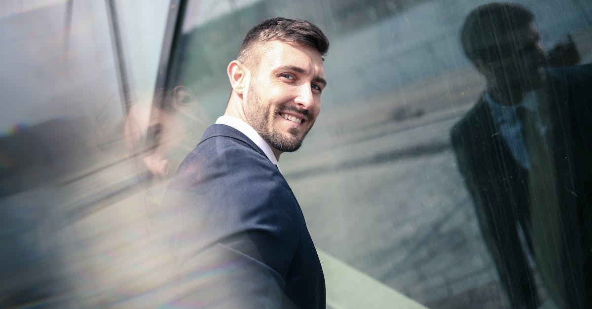 Dying Light: Grenades Don't Work Well - Cheerful businessman in formal wear standing in front of glass wall Dying Light: Grenades Don't Work Well - Cheerful businessman in formal wear standing in front of glass wall