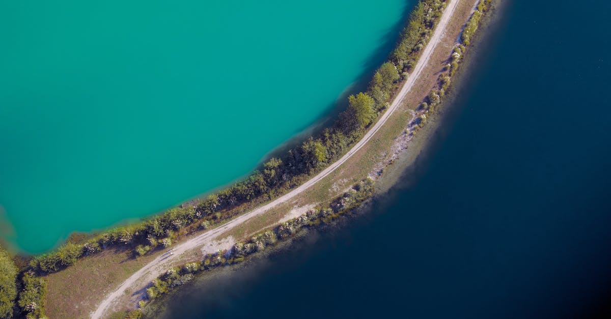 Easiest way to dig deep quickly - Aerial view of narrow curvy road running between lagoon of rich turquoise color and ocean surface with dark blue water Easiest way to dig deep quickly - Aerial view of narrow curvy road running between lagoon of rich turquoise color and ocean surface with dark blue water