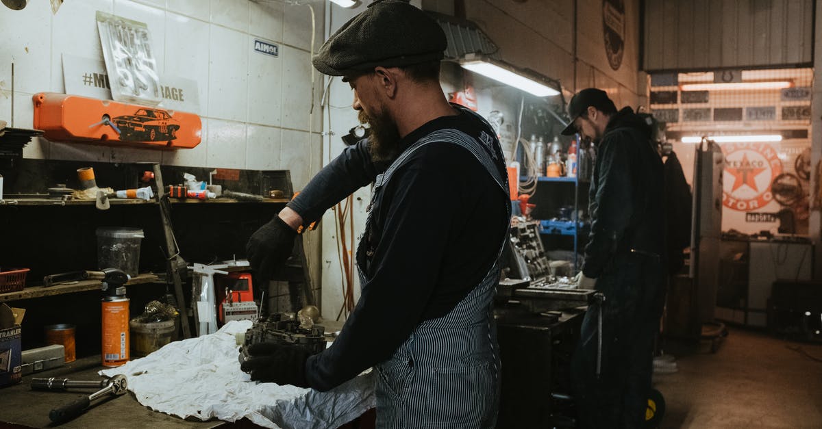 Easily scrap large amounts of gear - Man in Black Long Sleeve Shirt and Gray Pants Standing in Front of Table