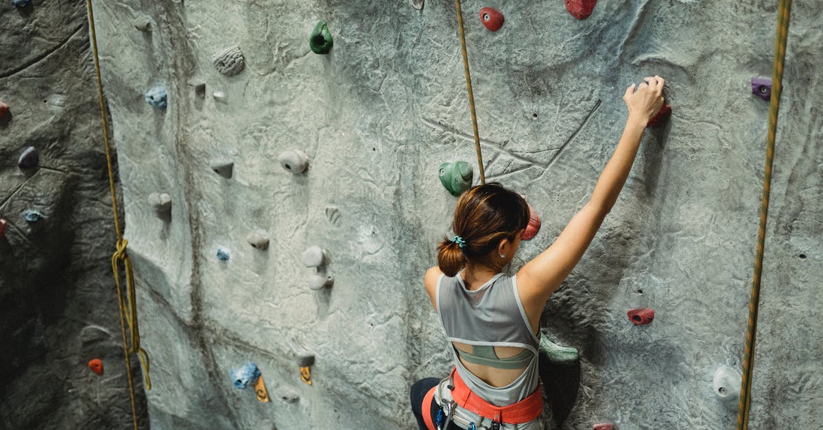 Effectively training multiple formations - Fearless young woman climbing rocky rough wall