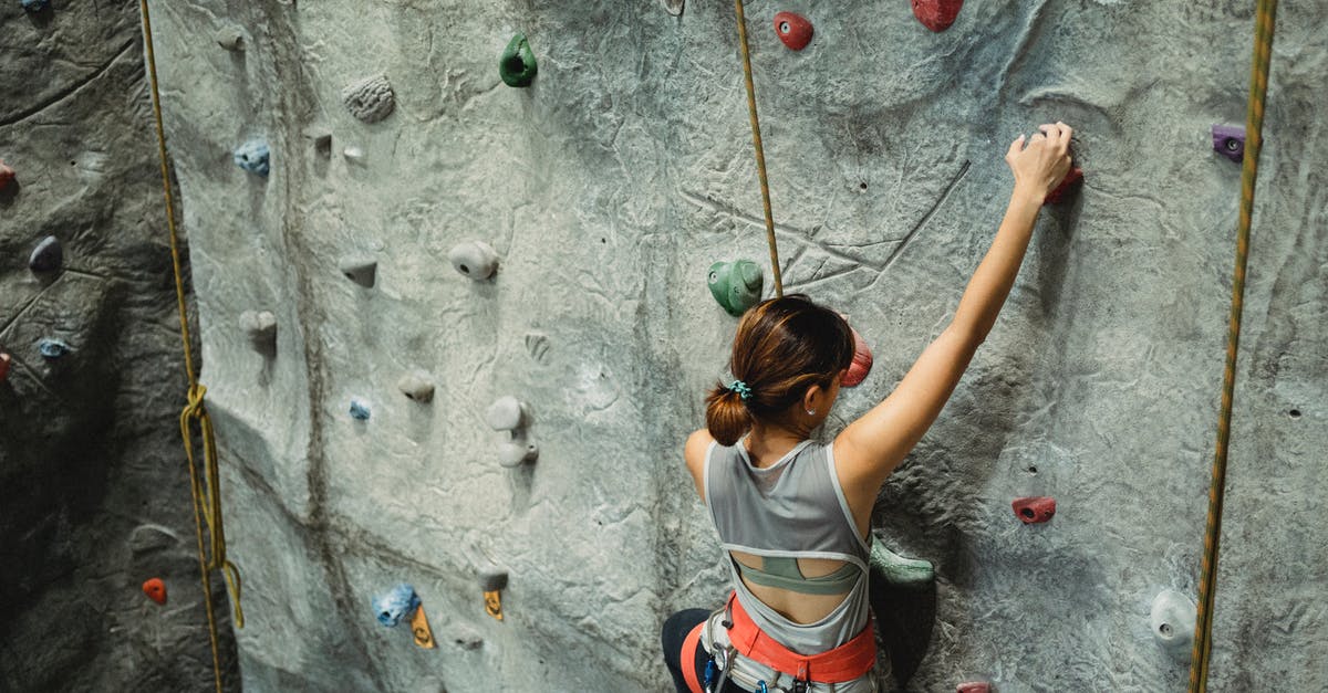 Effectively training multiple formations - Fearless young woman climbing rocky rough wall Effectively training multiple formations - Fearless young woman climbing rocky rough wall