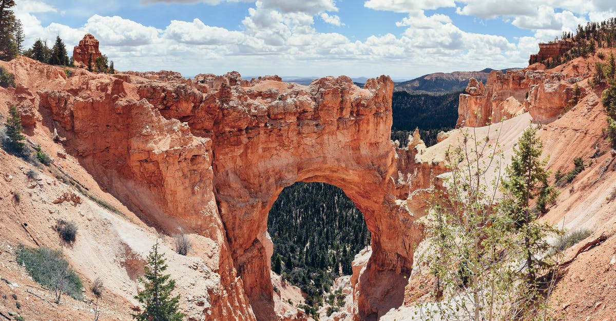 Elite Dangerous: NPC Arch Enemies? - Natural arch in valley under cloudy sky