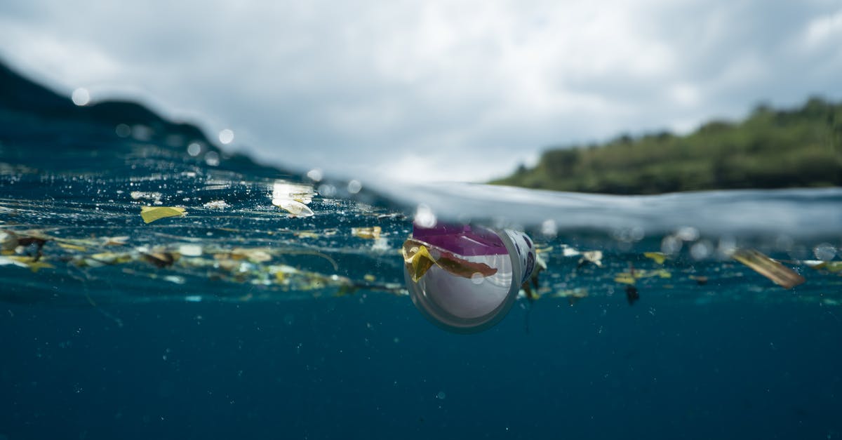 Elite Dangerous: Value of Planet Surface Mapping - Plastic and rubbish floating in blue water of ocean against green island in daytime Elite Dangerous: Value of Planet Surface Mapping - Plastic and rubbish floating in blue water of ocean against green island in daytime