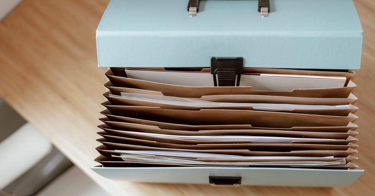 End data folder location - From above of briefcase for documents with papers placed on wooden table in daytime End data folder location - From above of briefcase for documents with papers placed on wooden table in daytime
