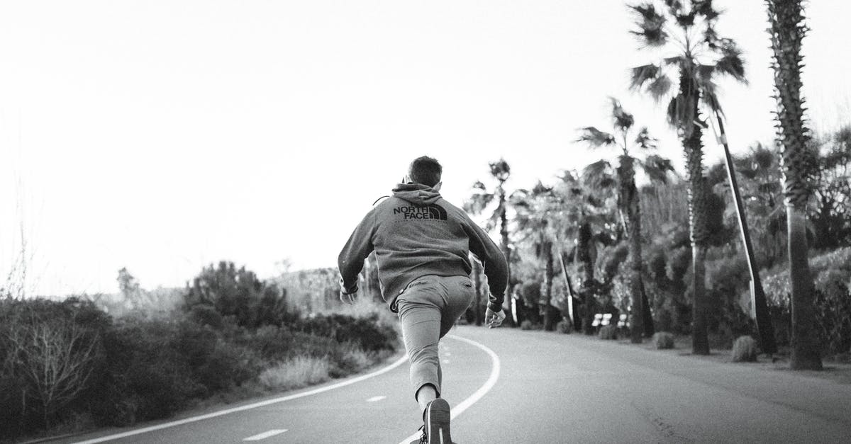 Eve: how my speed impacts ability of opponent to hit me? - Black and white of anonymous male skater riding skateboard on empty roadway between palms and plants Eve: how my speed impacts ability of opponent to hit me? - Black and white of anonymous male skater riding skateboard on empty roadway between palms and plants