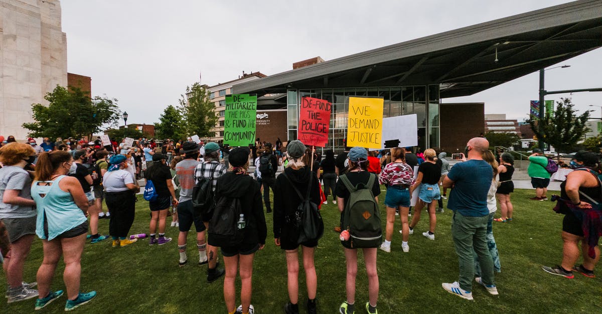 Event to change to Nomad CK2 - Rebel people with strike banners gathering near modern building Event to change to Nomad CK2 - Rebel people with strike banners gathering near modern building