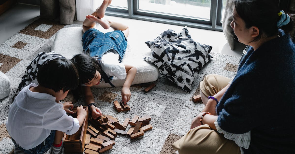 Execute command relative to block - From above of Asian boy and girl playing with wooden blocks near window on floor in living room with grandmother Execute command relative to block - From above of Asian boy and girl playing with wooden blocks near window on floor in living room with grandmother