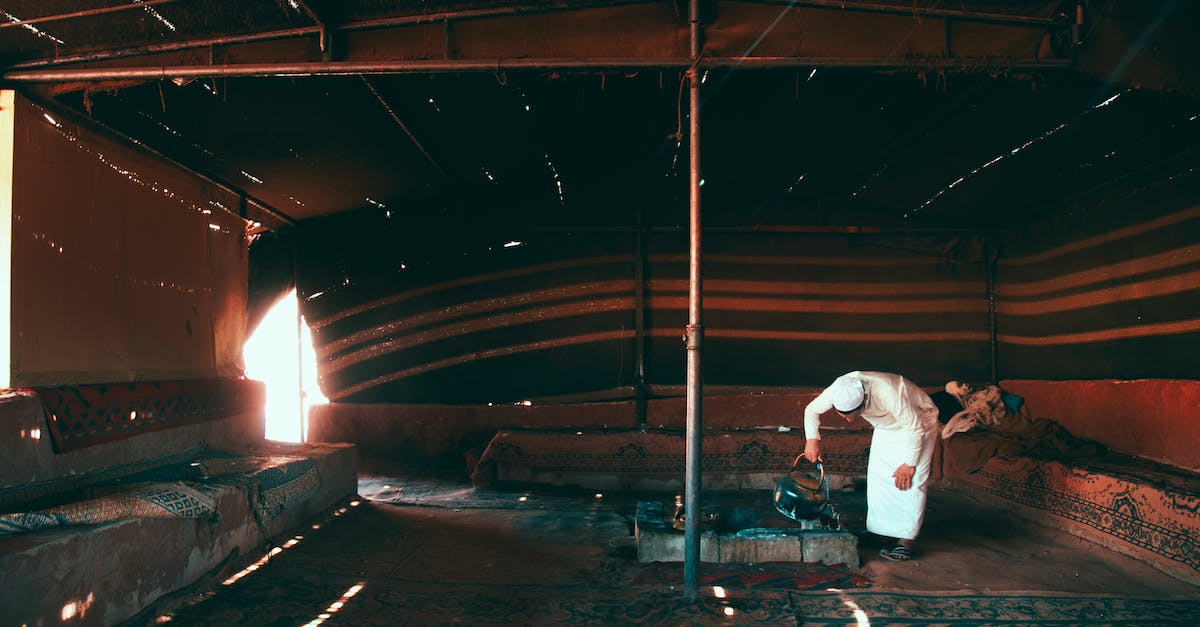 Exterminate the Death Claws in Original Fallout - Man in Traditional Dress Heating Water in a Metal Kettle in a Tent