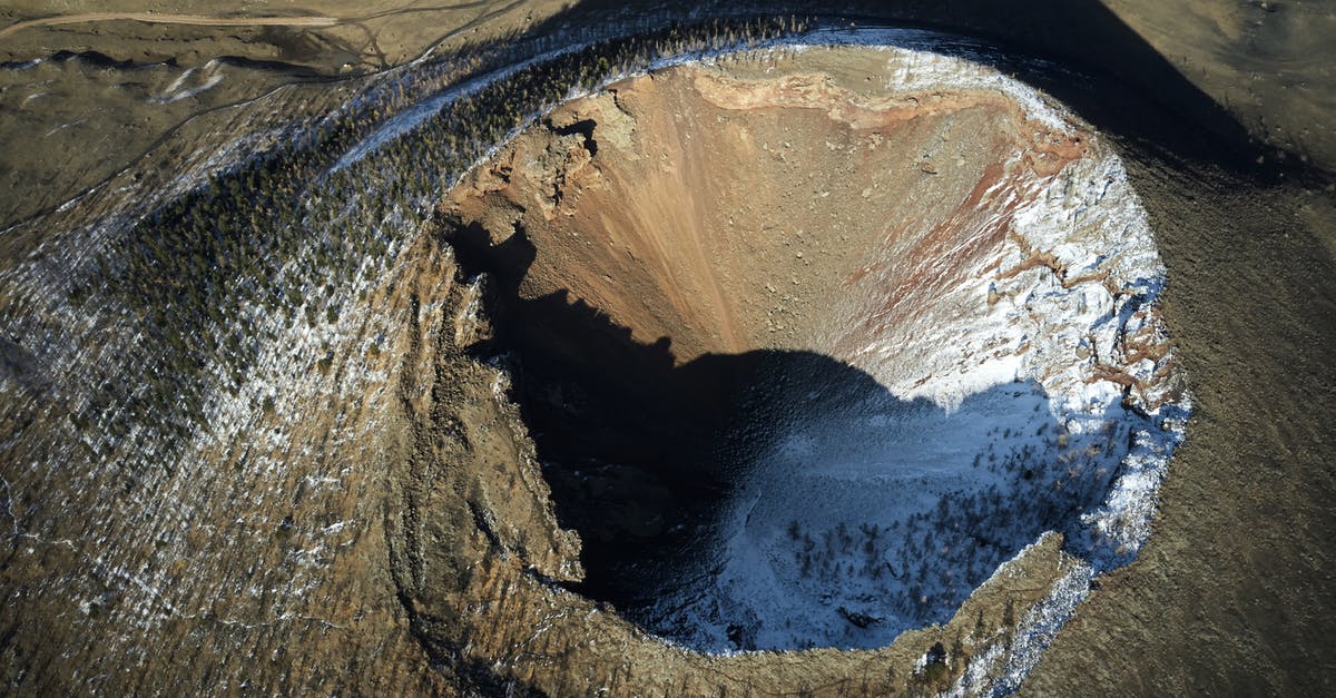 Extinction of the dwarves - Breathtaking aerial view of Khorgo Uul Mongolian extinct volcano forested on sides and covered with snow in bright sunlight Extinction of the dwarves - Breathtaking aerial view of Khorgo Uul Mongolian extinct volcano forested on sides and covered with snow in bright sunlight