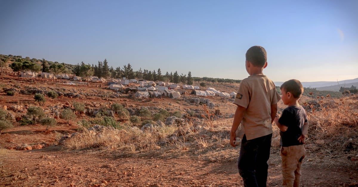Fallout shelter - Constantly complaining about dead bodies [duplicate] - Back view full body of ethnic homeless kids standing on dry ground with tents at distance