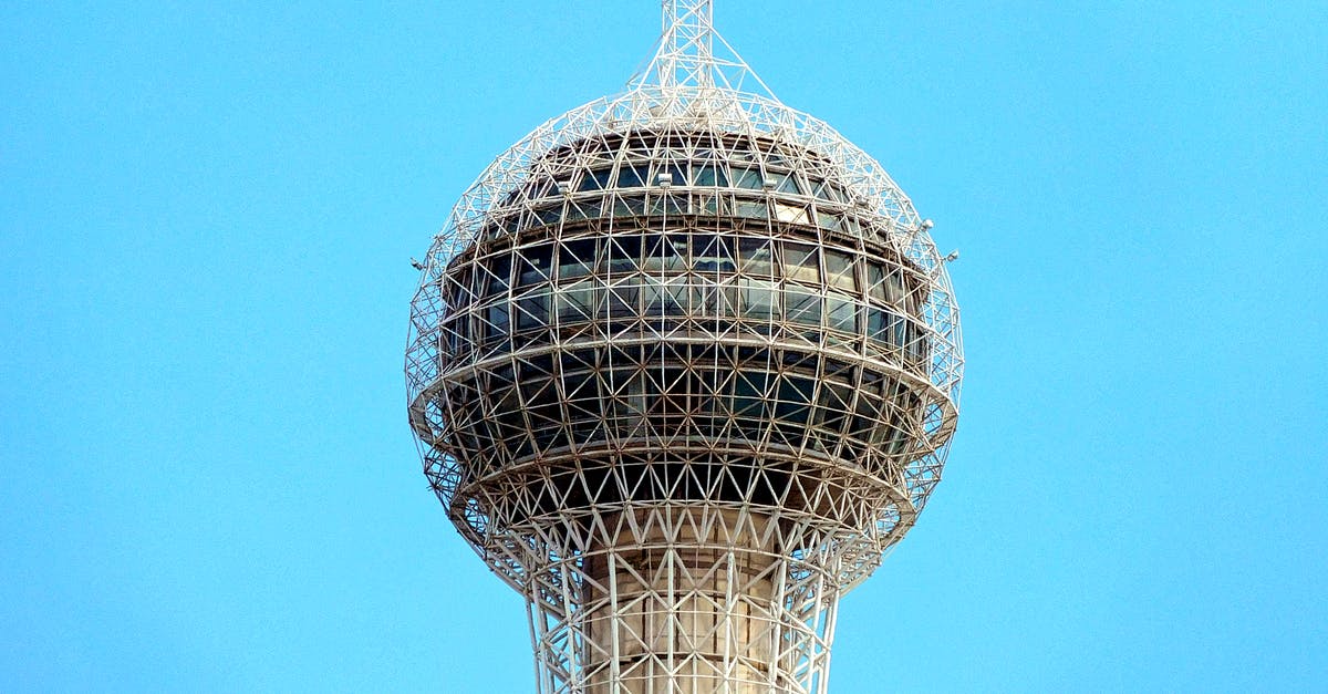 Fallout shelter Broadcast Center - Top of high rise modern broadcasting tower with globe against cloudless blue sky