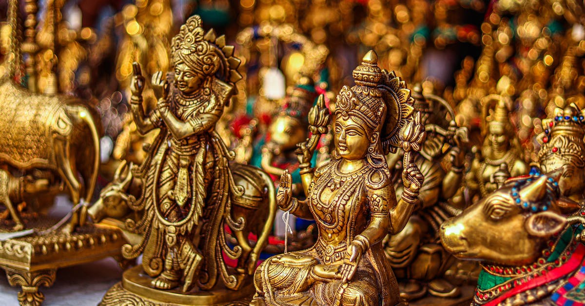 fame on realm of the mad god [duplicate] - Gold Hindu Deity Figurine on Brown Wooden Table