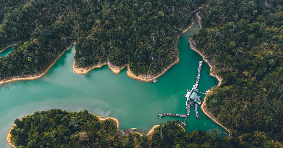 Far Harbor settlements - Breathtaking drone view of houses on water and sandy coastline surrounded by exotic forest and lagoon Far Harbor settlements - Breathtaking drone view of houses on water and sandy coastline surrounded by exotic forest and lagoon