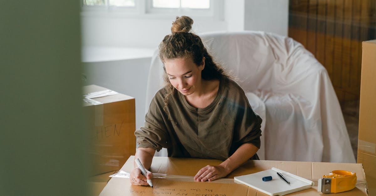 FFXIV window size - Woman signing box with marker while sitting in living room FFXIV window size - Woman signing box with marker while sitting in living room