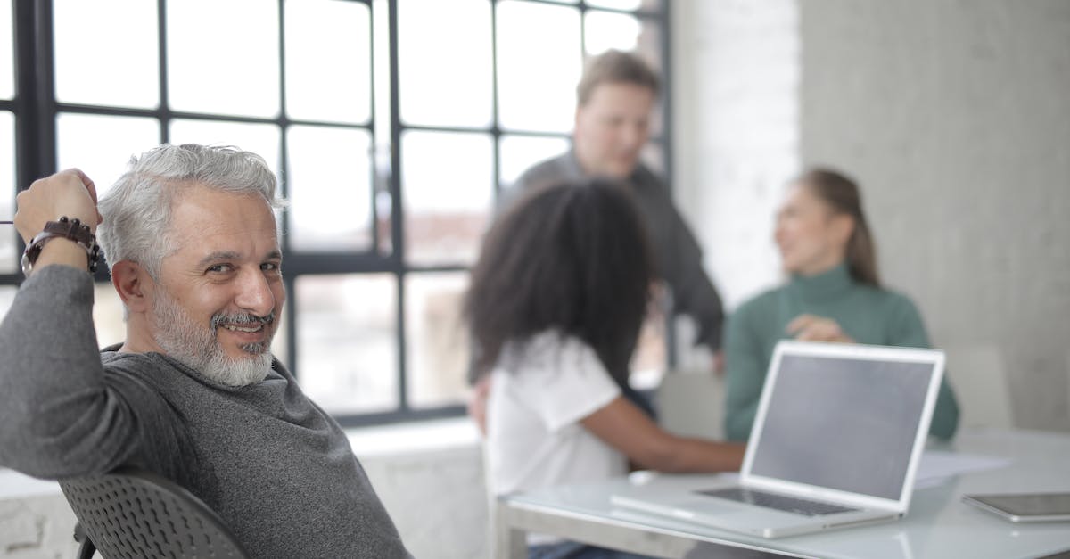 FIFA 15:UT Windows 10 black screen - Happy worker sitting in front of laptop with multiethnic colleagues FIFA 15:UT Windows 10 black screen - Happy worker sitting in front of laptop with multiethnic colleagues