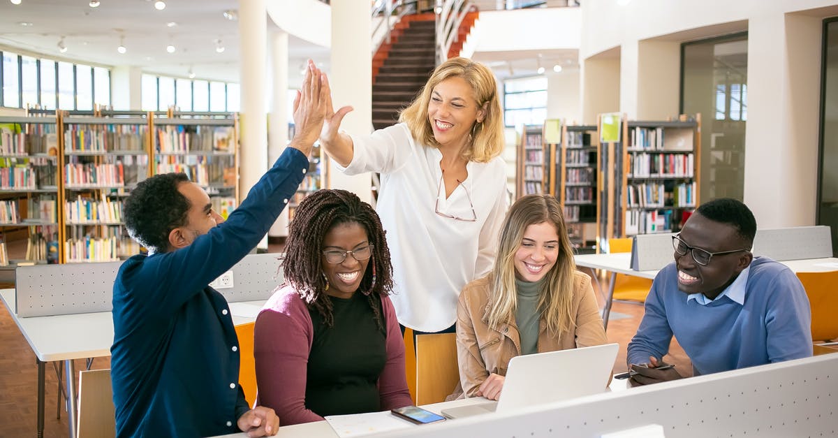 First challenger loses but team win means elimination? - Cheerful multiethnic students having high five with teacher