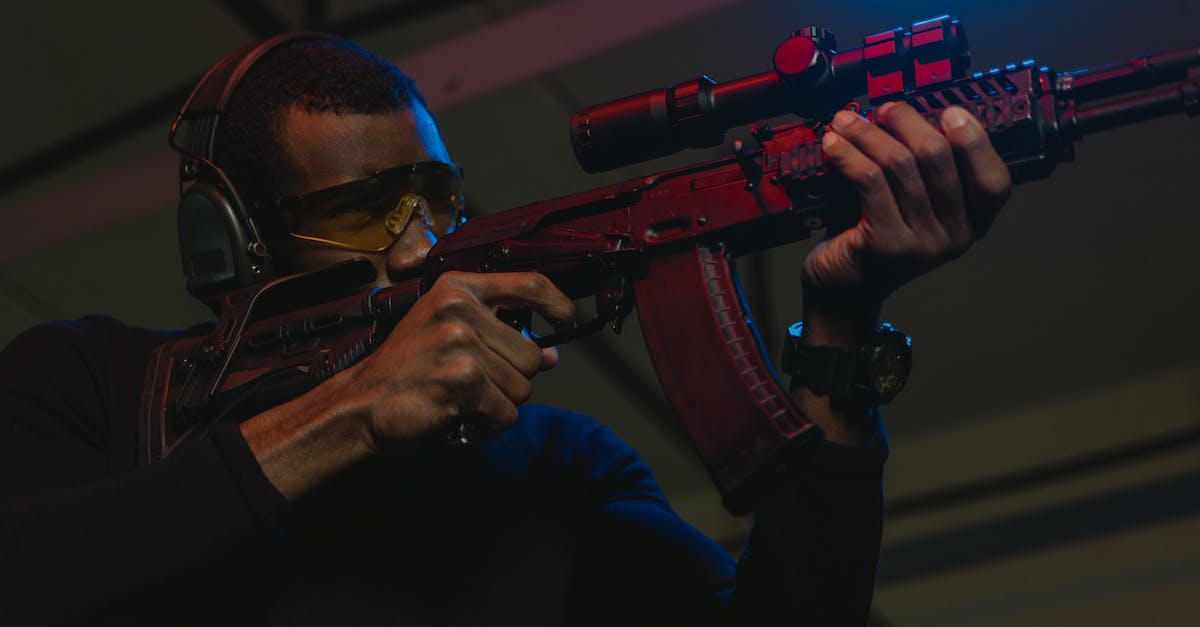 First Rifle with Scope - Man in Black Long Sleeve Shirt Holding Black Rifle First Rifle with Scope - Man in Black Long Sleeve Shirt Holding Black Rifle