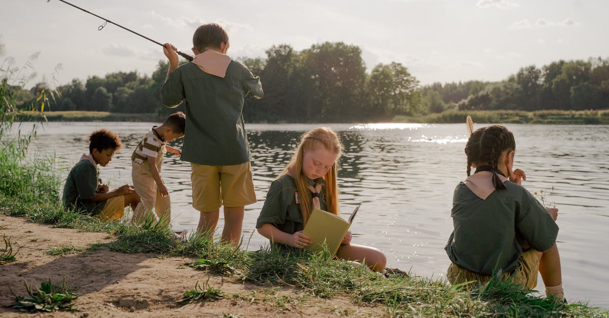 Fishing Difficulty Differences? - Man in Gray Shirt Sitting Beside Girl in Yellow Shirt and Black Pants Sitting on Brown