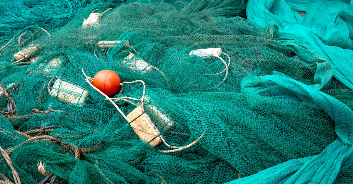 Fishing Difficulty Differences? - High angle of fishing net with floats and ropes against creased green fabric in daytime Fishing Difficulty Differences? - High angle of fishing net with floats and ropes against creased green fabric in daytime