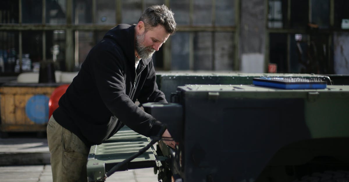 Fix broken aspect ratio for in-home streaming of "The World Next Door"? - Adult bearded mechanic fixing metal part of car on street near garage