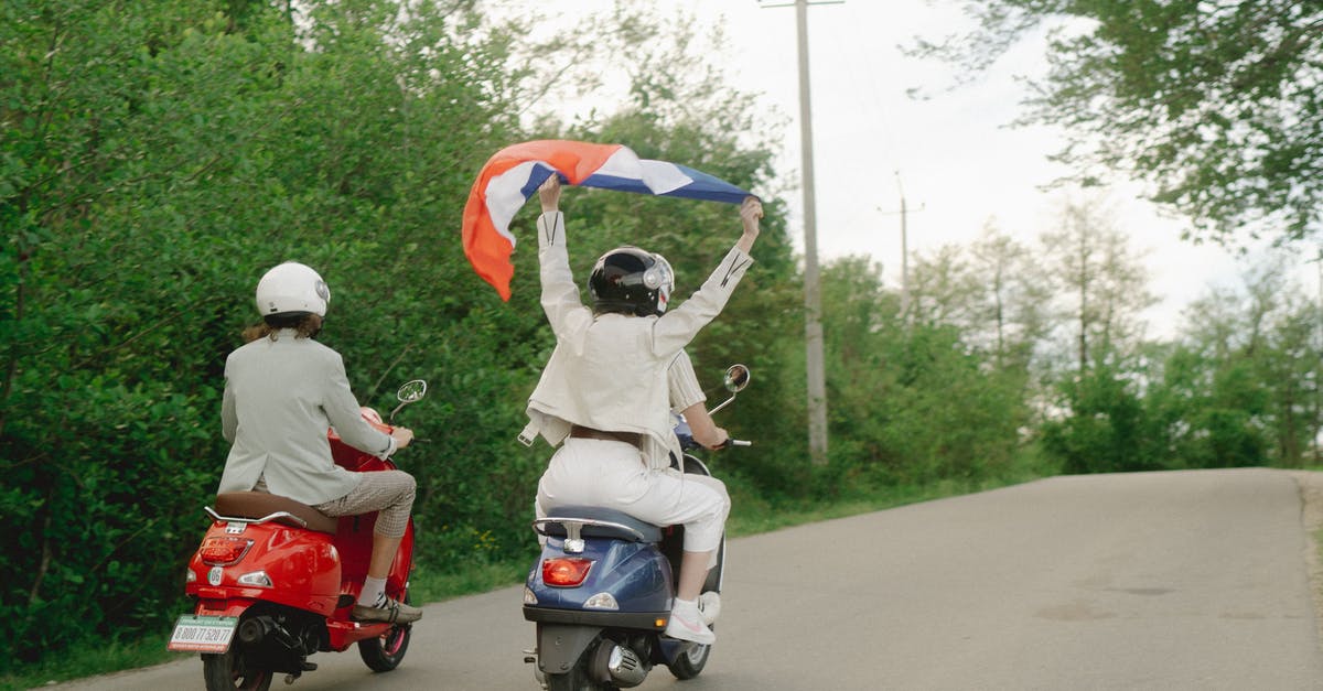 FOB holding too much resource materials and vehicles - People Riding a Motor Scooters on the Road while Holding a Flag