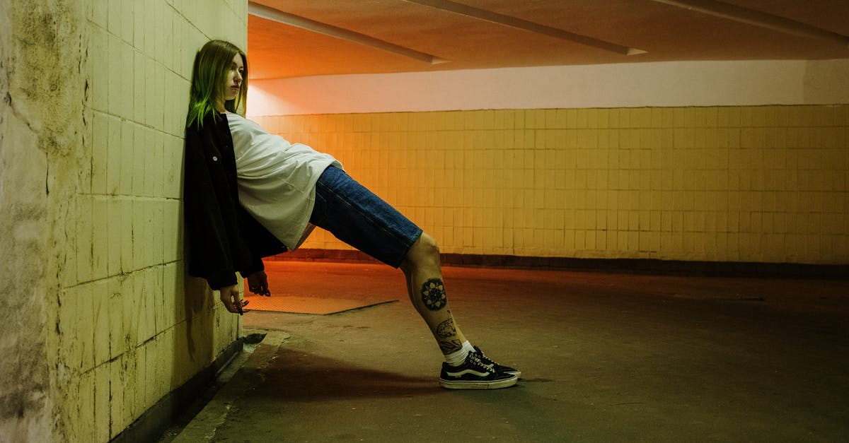 Forcing a faction to revolt - Woman in White Long Sleeve Shirt and Blue Denim Jeans Sitting on Gray Concrete Floor Forcing a faction to revolt - Woman in White Long Sleeve Shirt and Blue Denim Jeans Sitting on Gray Concrete Floor