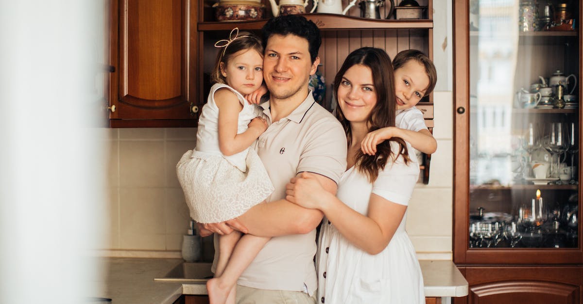 Foreigner son-in-law went on a killing spree, then formed a militia just to stand around for awhile... did I miss something? - Cheerful family standing together at kitchen