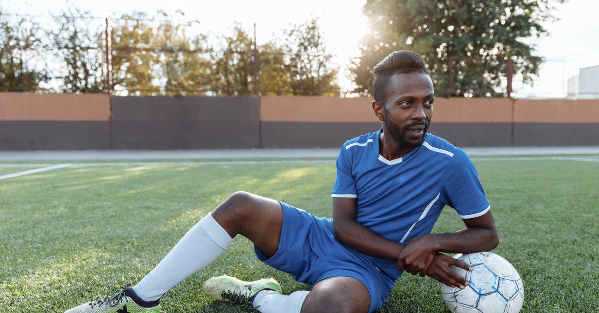 Forgot Player ID for Pokemon.com - Man in Blue and White Crew Neck T-shirt and Blue Shorts Sitting on Green Grass