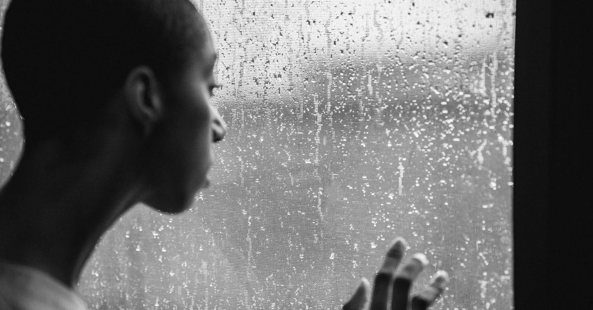Framerate drop when looking at panels? - Thoughtful androgynous black woman standing near window at rainy day Framerate drop when looking at panels? - Thoughtful androgynous black woman standing near window at rainy day