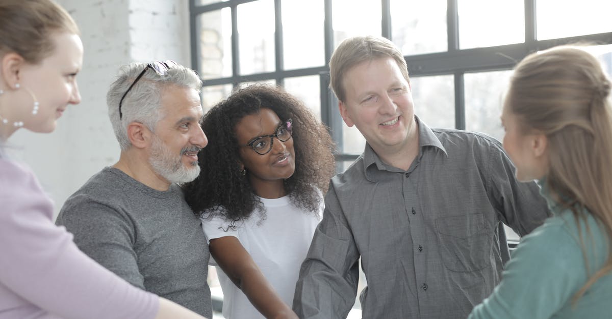 Friends can't join my group but I can join their group - Cheerful diverse colleagues joining hands after coming to agreement Friends can't join my group but I can join their group - Cheerful diverse colleagues joining hands after coming to agreement