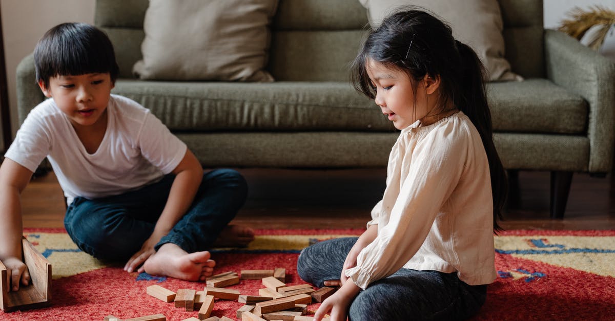 Game crashes when I open my friend's tower - Adorable ethnic kids playing jenga at home on floor Game crashes when I open my friend's tower - Adorable ethnic kids playing jenga at home on floor
