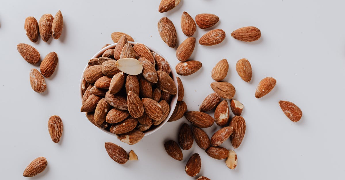 Game Menu Opening Randomly - Bowl filled with raw almond nuts on white background Game Menu Opening Randomly - Bowl filled with raw almond nuts on white background