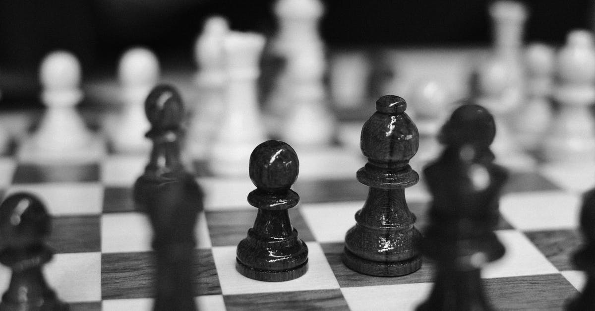 Game minimizing during play - Black and white of wooden chessboard with placed chess pieces against blurred background