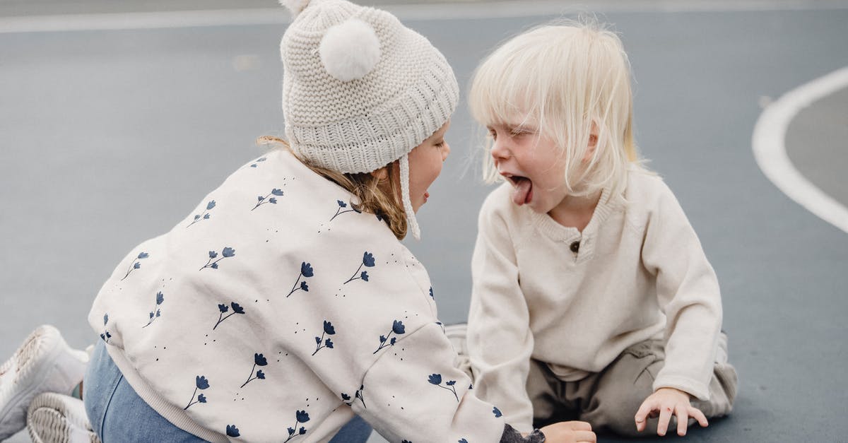 GameCube Games with Bonus Content on Wii [closed] - Side view of cute little girl with hat and playful boy showing tongue sitting on sports ground while having fun against blurred background