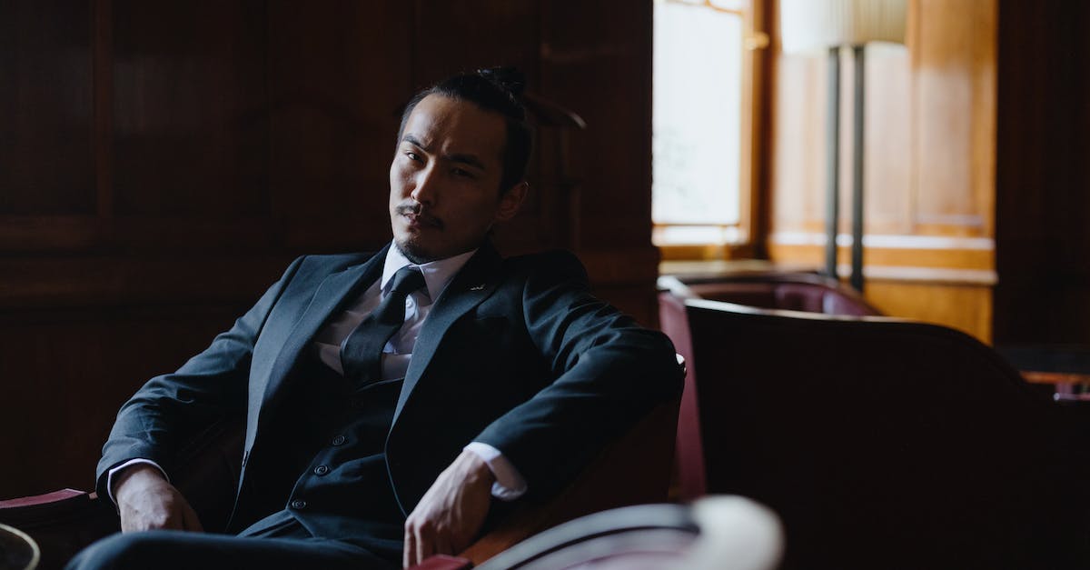 Gangster and M1SMG, what is the difference? - Man in Black Suit Sitting on Chair