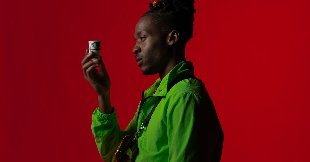 Gangster and M1SMG, what is the difference? - Man in Green Button Up Shirt Holding Rolled Banknotes