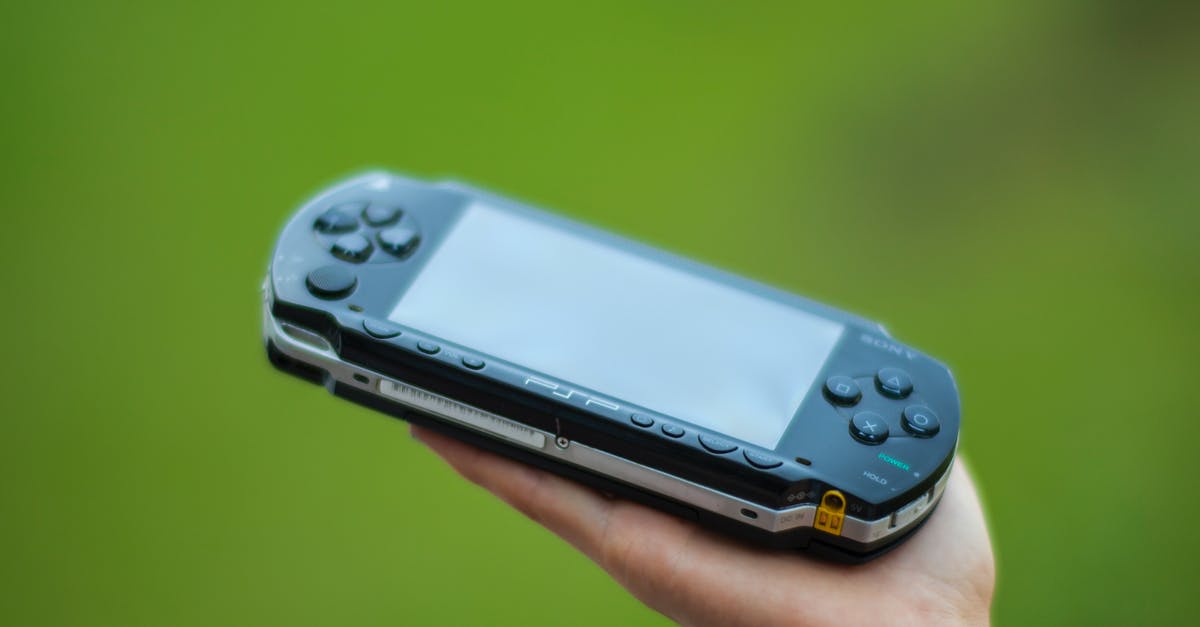 General term for the technology that allows games to be replayed? - Closeup Photography of Person Holding  Black Sony Psp Handheld Console