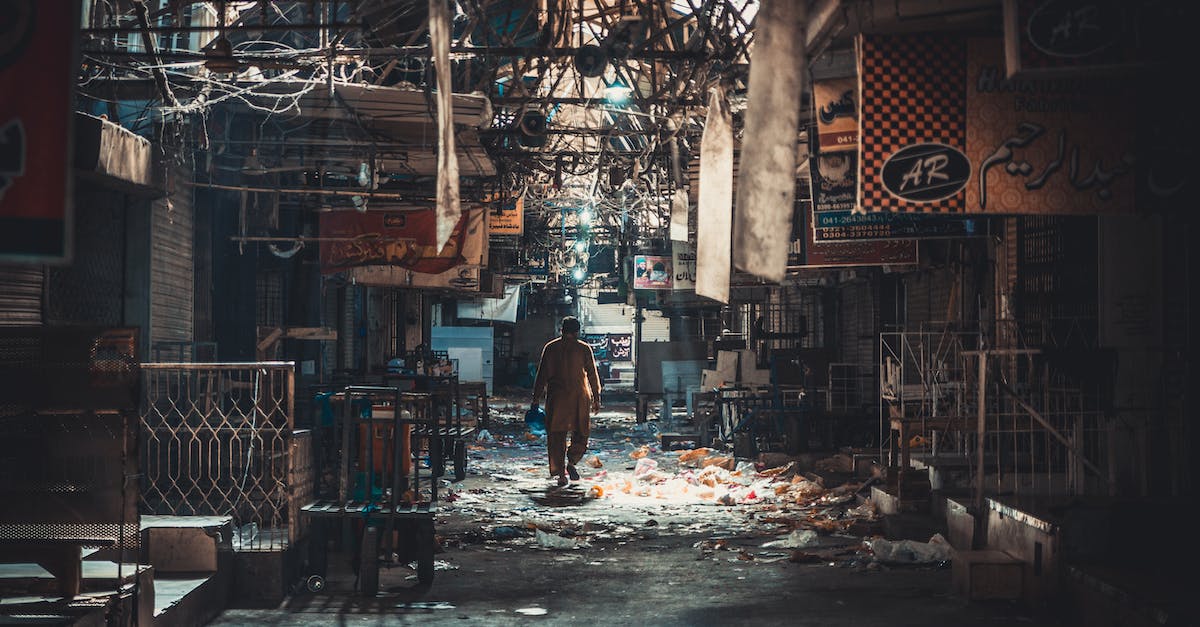 Getting back in the waste exchange in batman arkham city. - Man Wearing Yellow Overall Pants Between Buildings