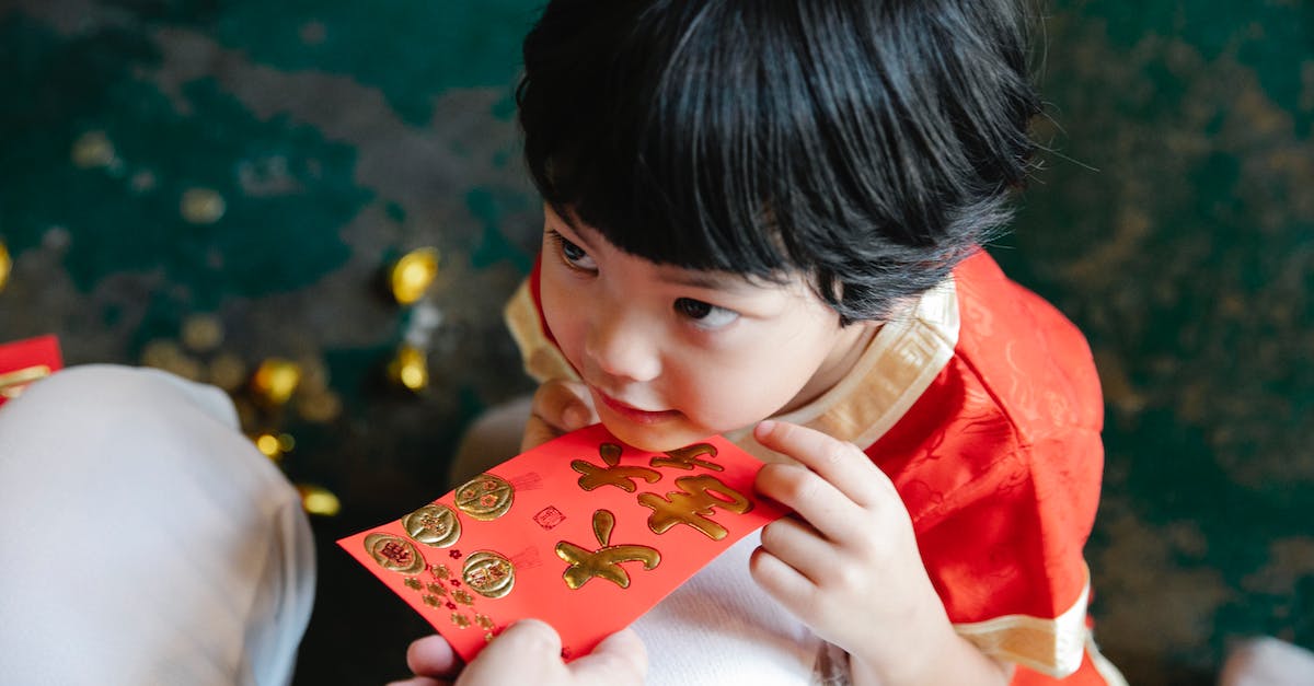 Gifting Battle.net Money - Crop mother giving hongbao red packet to son during New Year party Gifting Battle.net Money - Crop mother giving hongbao red packet to son during New Year party