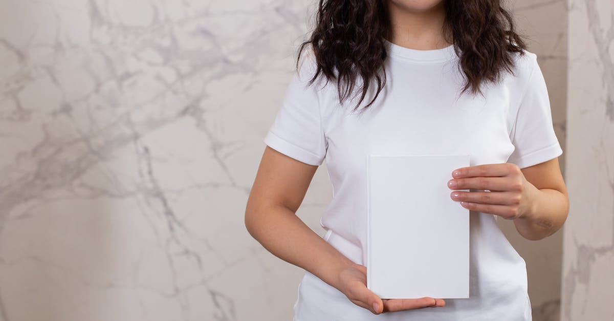Google login method doesn't show [duplicate] - Unrecognizable female with black hair and casual t shirt showing white black notepad while standing near wall in light room