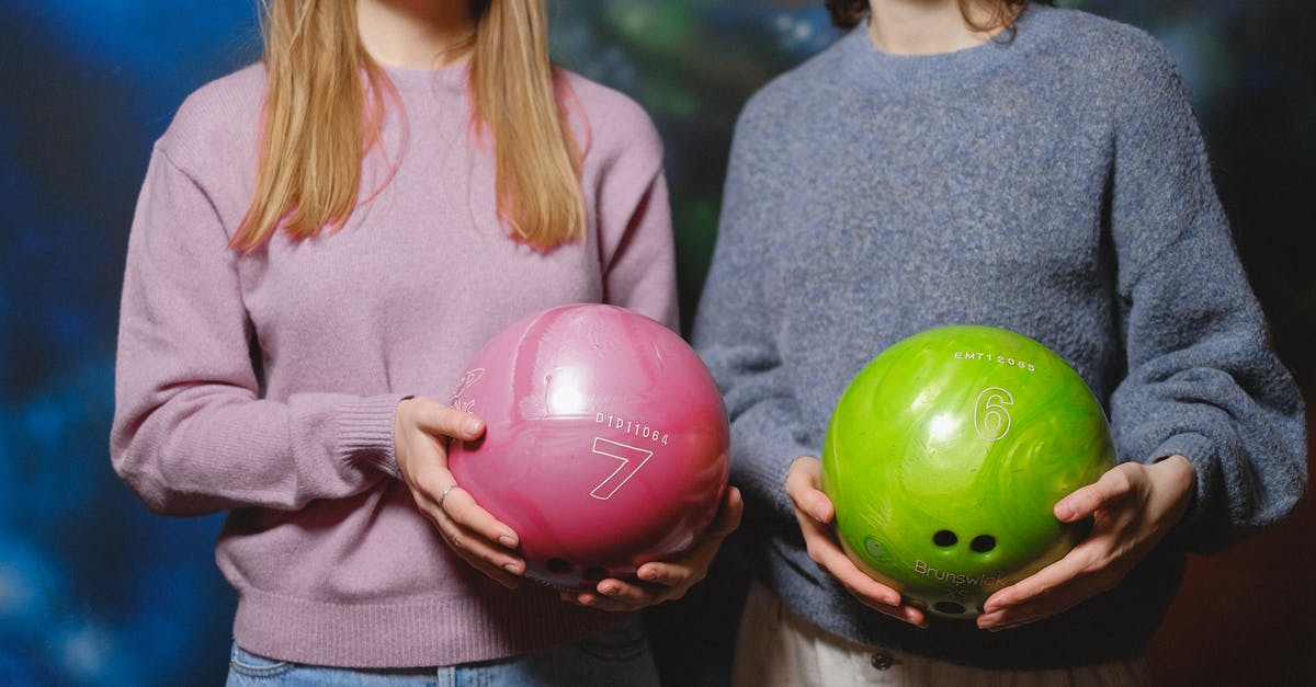 Great Balls are always curveballing - Woman in Gray Long Sleeve Shirt Holding Two Purple and Green Balloons Great Balls are always curveballing - Woman in Gray Long Sleeve Shirt Holding Two Purple and Green Balloons