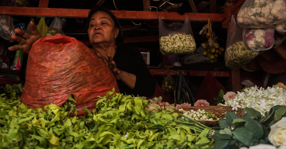 Gree Enclave Reputation Vendor available? - Woman in Black Long Sleeve Shirt Sitting on Chair in Front of Vegetable Stand