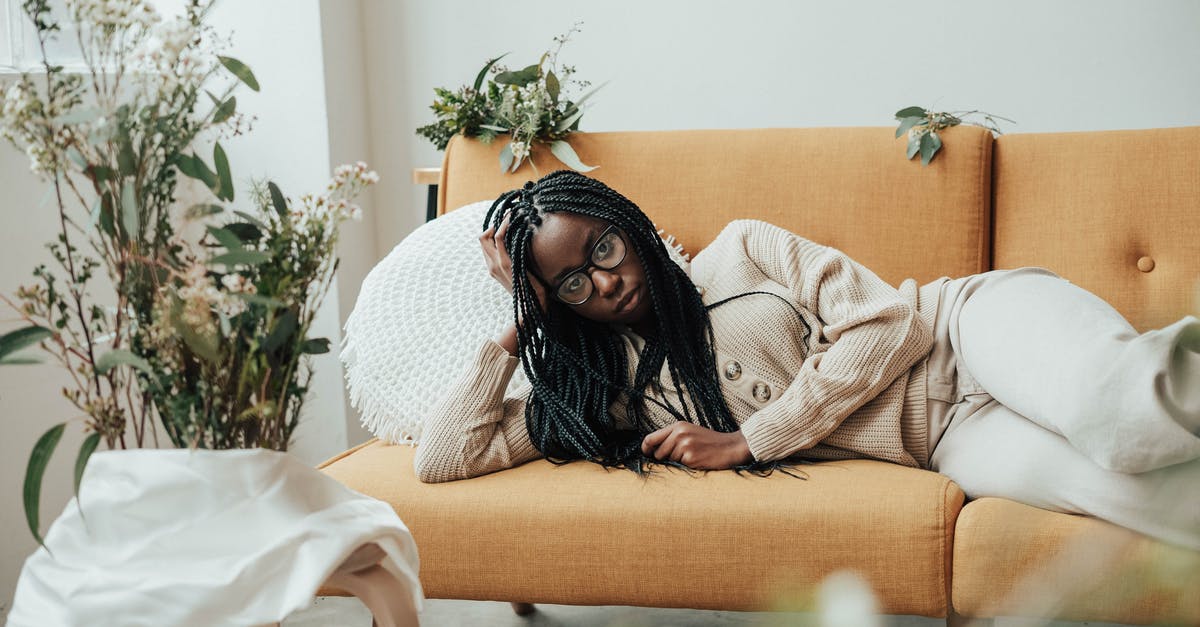 Green logic fault in Braid - Serious African American woman on couch near plants and flowers