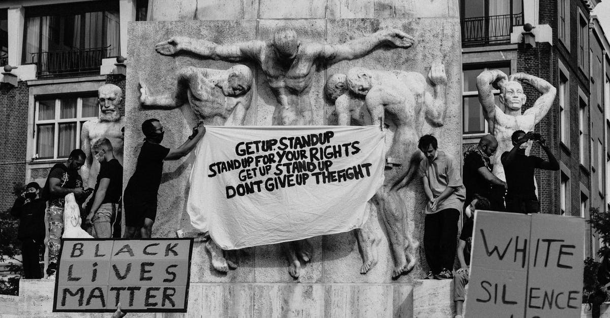 Group progress for Elite Dungeons - Black and white of crowd of people standing on city street with carton boards during social protest Group progress for Elite Dungeons - Black and white of crowd of people standing on city street with carton boards during social protest