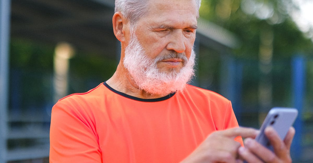 GTA 5 Online missions not appearing? - Crop elderly bearded male with gray hair browsing modern mobile phone while spending time in park GTA 5 Online missions not appearing? - Crop elderly bearded male with gray hair browsing modern mobile phone while spending time in park