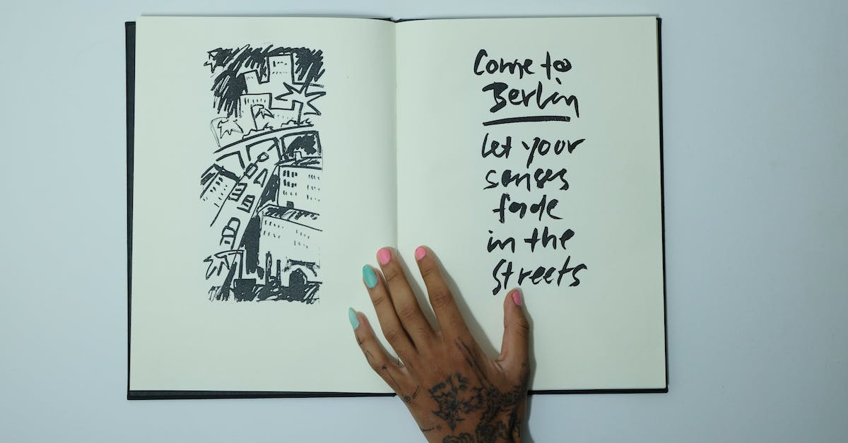 Guard dogs: where do they come from? - Unrecognizable woman with opened sketchbook with inscription and drawing Guard dogs: where do they come from? - Unrecognizable woman with opened sketchbook with inscription and drawing