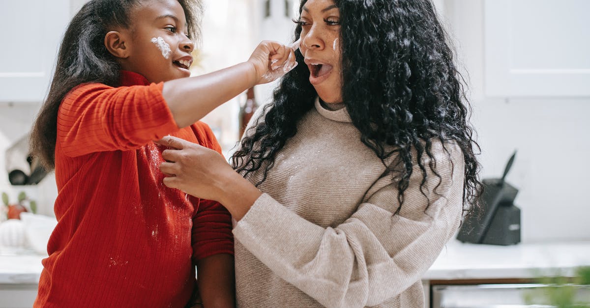 Having a 50-50 chance apply to commands [duplicate] - Positive dirty ethnic child applying flour on face of young crop parent while having fun in kitchen and looking at each other