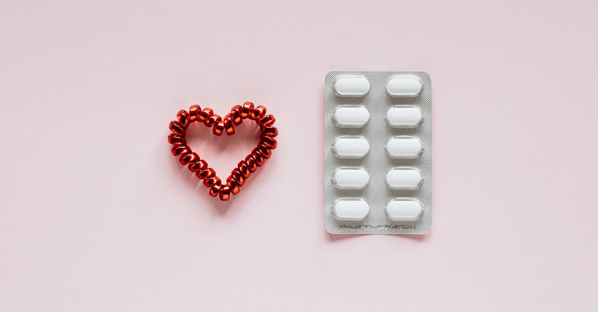 Heart containers which are painful to miss? - Composition of heart and pills on pink background