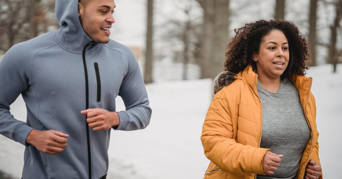 Help me run the numbers on a perfect IV ditto - Positive African American male personal instructor running with overweight female in park in winter day Help me run the numbers on a perfect IV ditto - Positive African American male personal instructor running with overweight female in park in winter day