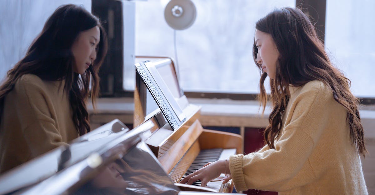 Hide the UI and take a screenshot with one key press - Side view of focused ethnic female musician sitting near piano and pressing keys in daylight from big window Hide the UI and take a screenshot with one key press - Side view of focused ethnic female musician sitting near piano and pressing keys in daylight from big window